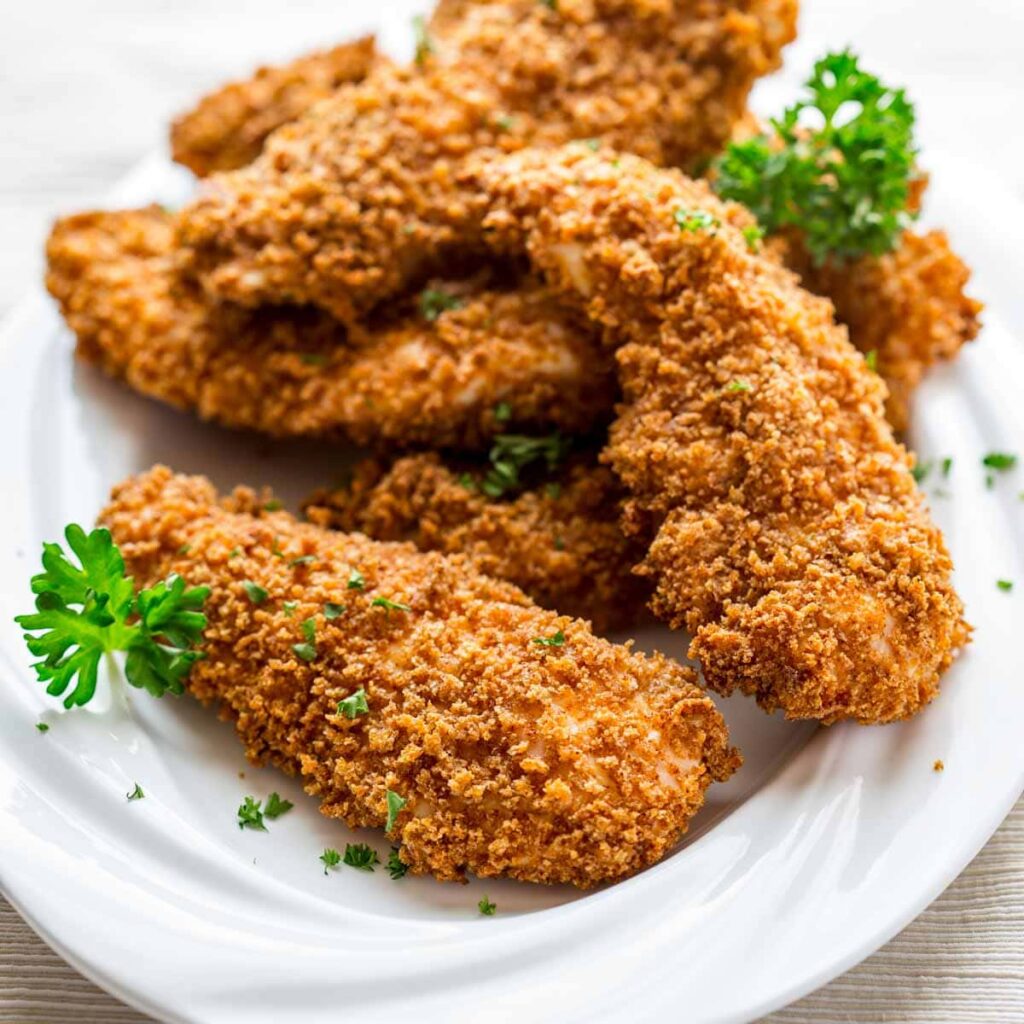 Four chicken fingers with homemade fries and a small soup.